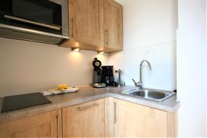 a kitchen with wooden cabinets and a sink at Ferienwohnung Neuschwanstein in Füssen