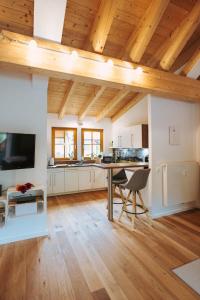フュッセンにあるDas Feriennestの木製の天井、テーブルと椅子付きのキッチン