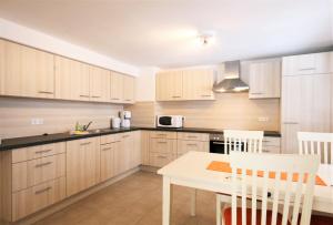 a kitchen with wooden cabinets and a white table at Ferienwohnung Alpenrose in Pfronten