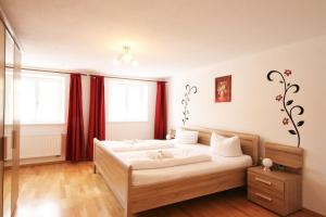 プフロンテンにあるFerienwohnung Alpenroseのベッドルーム1室(赤いカーテン付きの大型ベッド1台付)