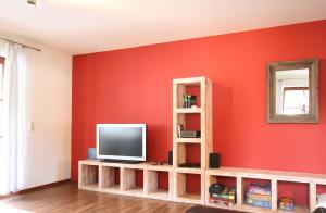a living room with a tv on a red wall at Ferienwohnung Steuer in Füssen