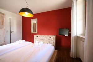 two beds in a room with a red wall at Ferienwohnung Steuer in Füssen
