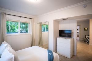 フォート・ローダーデールにあるWalk to Wilton Drive - Spacious & Quiet Villa #1のベッドと薄型テレビのある寝室