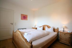 フュッセンにあるFerienhaus Seeroseのベッドルーム(白いシーツを使用した大型ベッド1台付)