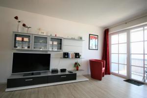 ein Wohnzimmer mit einem Flachbild-TV und einem roten Stuhl in der Unterkunft Ferienwohnung Stephan in Füssen