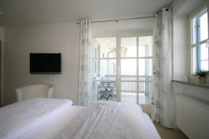 a bedroom with two beds and a balcony with a television at Ferienwohnung Stephan in Füssen