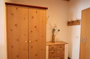 a wooden cabinet in a room with a wooden dresser at Ferienwohnung Forggensee-Blick in Schwangau +2 photos