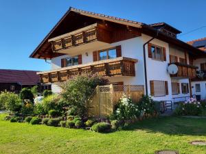 a large house with wooden balconies and a yard at Ferienwohnung Beim Ivo in Roßhaupten