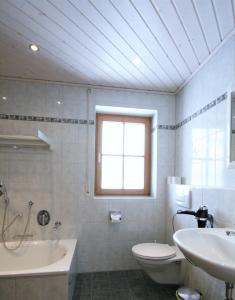 een badkamer met een wastafel, een bad en een toilet bij Ferienwohnung Romi in Pfronten