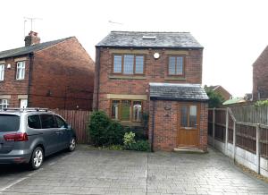 a car parked in front of a brick house at 3br House Ossett-Wakefield, Free Parking 3 cars Wi Fi Long stays in Wakefield