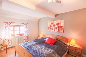 - une chambre avec un lit doté d'un oreiller rouge dans l'établissement Ferienwohnung Schwalbennest, à Emmelsbüll-Horsbüll