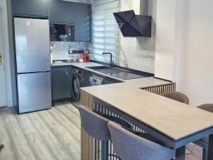 a kitchen with a refrigerator and a table with chairs at Alcaidesa, luxury apartment with sea views in Alcaidesa
