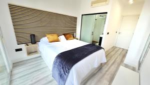 a bedroom with a large white bed with yellow pillows at Alcaidesa, luxury apartment with sea views in Alcaidesa