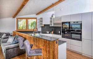 uma cozinha com armários brancos e um balcão de madeira em Eagles Nest - by Alpen Apartments em Zell am See