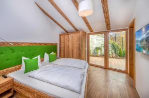 um quarto com uma cama com uma cabeceira verde em Eagles Nest - by Alpen Apartments em Zell am See