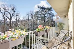 een balkon met bloemen en een stoel bij Very nice apt in the heart of Neuilly with Parking in Neuilly-sur-Seine