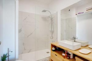 een witte badkamer met een wastafel en een douche bij Very nice apt in the heart of Neuilly with Parking in Neuilly-sur-Seine
