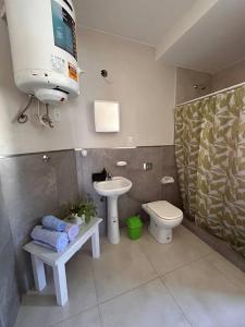 TV y baño con lavabo y aseo. en Alojamiento Céntrico en Posadas