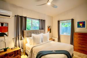 una camera da letto con un letto grande con cuscini bianchi di Walk to Wilton Drive - Spacious & Quiet Villa #2 HOT TUB! a Fort Lauderdale