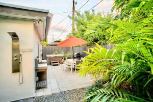 un patio con tavolo, sedie e ombrellone di Walk to Wilton Drive - Spacious & Quiet Villa #2 HOT TUB! a Fort Lauderdale