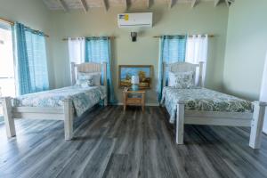 a bedroom with two beds and a mirror at The Ti-Kaye Oasis in Crab Hill