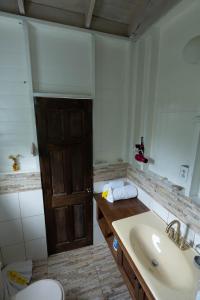 baño con lavabo, aseo y puerta en The Ti-Kaye Oasis en Crab Hill