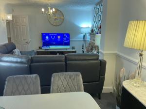 a living room with a couch and a tv at MAYE HOUSE 