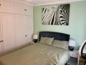 a bedroom with a bed with a zebra picture on the wall at MAYE HOUSE 