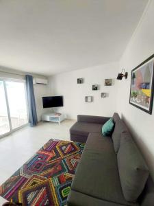 uma sala de estar com um sofá e uma televisão em House of Love Portimão em Portimão