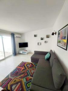 a living room with a couch and a television at House of Love Portimão in Portimão