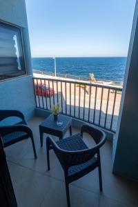 XgħajraにあるSG seaview apartmentの海を望むバルコニー(椅子、テーブル付)
