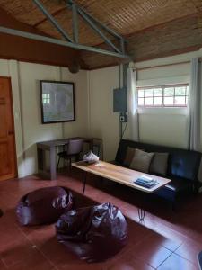 Studio House in Eco-Farm: nature, relaxing, hiking في توريالبا: غرفة معيشة مع أريكة وطاولة