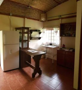 a kitchen with a refrigerator and a table in it at Studio House in Eco-Farm: nature, relaxing, hiking in Turrialba