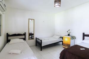 a room with two beds and a mirror at Pousada Villa Aruna in Barra Grande
