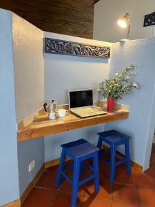 een bureau met een laptop en twee blauwe krukken bij La Estación de Tomine in Guatavita