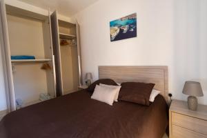 a bedroom with a large brown bed and a mirror at SG seaview apartment in Xgħajra