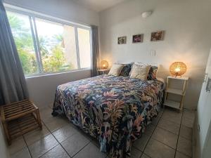 um quarto com uma cama e uma grande janela em Muri Retreat Apartments em Rarotonga