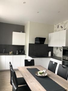 cocina con mesa de madera y armarios en blanco y negro en geräumige Ferienwohnung „Zum alten Forstamt“, en Clausthal-Zellerfeld