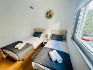 two twin beds in a room with a window at Luxe Forum Beach Terrace in Sant Adria de Besos +26 photos