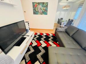 a living room with a couch and a large flat screen tv at Luxe Forum Beach Terrace in Sant Adria de Besos