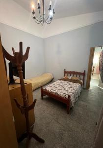 1 dormitorio con 2 camas y lámpara de araña en Chalet en YB en Yerba Buena