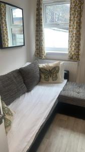 a large bed in a room with a butterfly pillow at 24 Kingsley gardens in Chingford