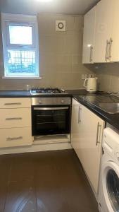 a small kitchen with a stove and a window at 24 Kingsley gardens in Chingford