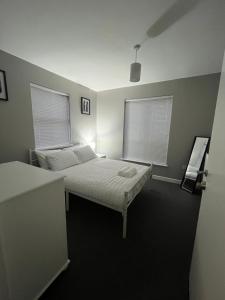 a bedroom with a bed and two windows at Apartment 4 Oak Villa in Belfast