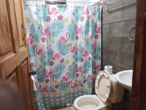 a bathroom with a shower curtain with a toilet at Apartamentos HJJ N 2 in Puerto Limón