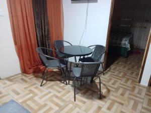 einen Glastisch und Stühle in einem Zimmer in der Unterkunft Apartamentos HJJ N 2 in Puerto Limón