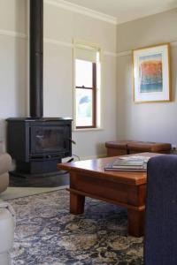 uma sala de estar com uma mesa e um fogão a lenha em Topsys Corner - large rural house near Orange 