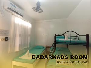 a bedroom with two bunk beds in a room at Medelaine's Beach Resort in Puerto Galera
