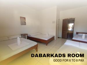 a hotel room with two beds and a bathroom at Medelaine's Beach Resort in Puerto Galera