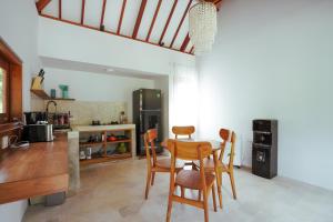 uma cozinha com uma mesa e quatro cadeiras em Karyana Apartment em Kuta Lombok